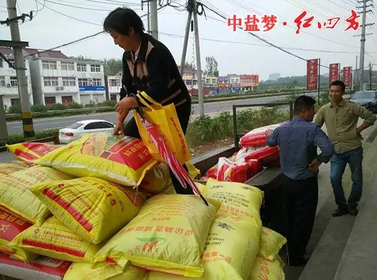 農戶拿著紅四方贈送的小禮品，樂滋滋地開著裝滿紅四方肥料的拖拉機準備回家